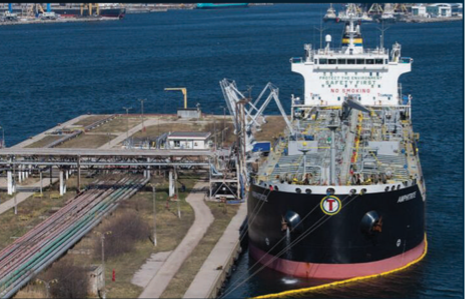 Tanker vessel loading at a port terminal with waste treatment infrastructure